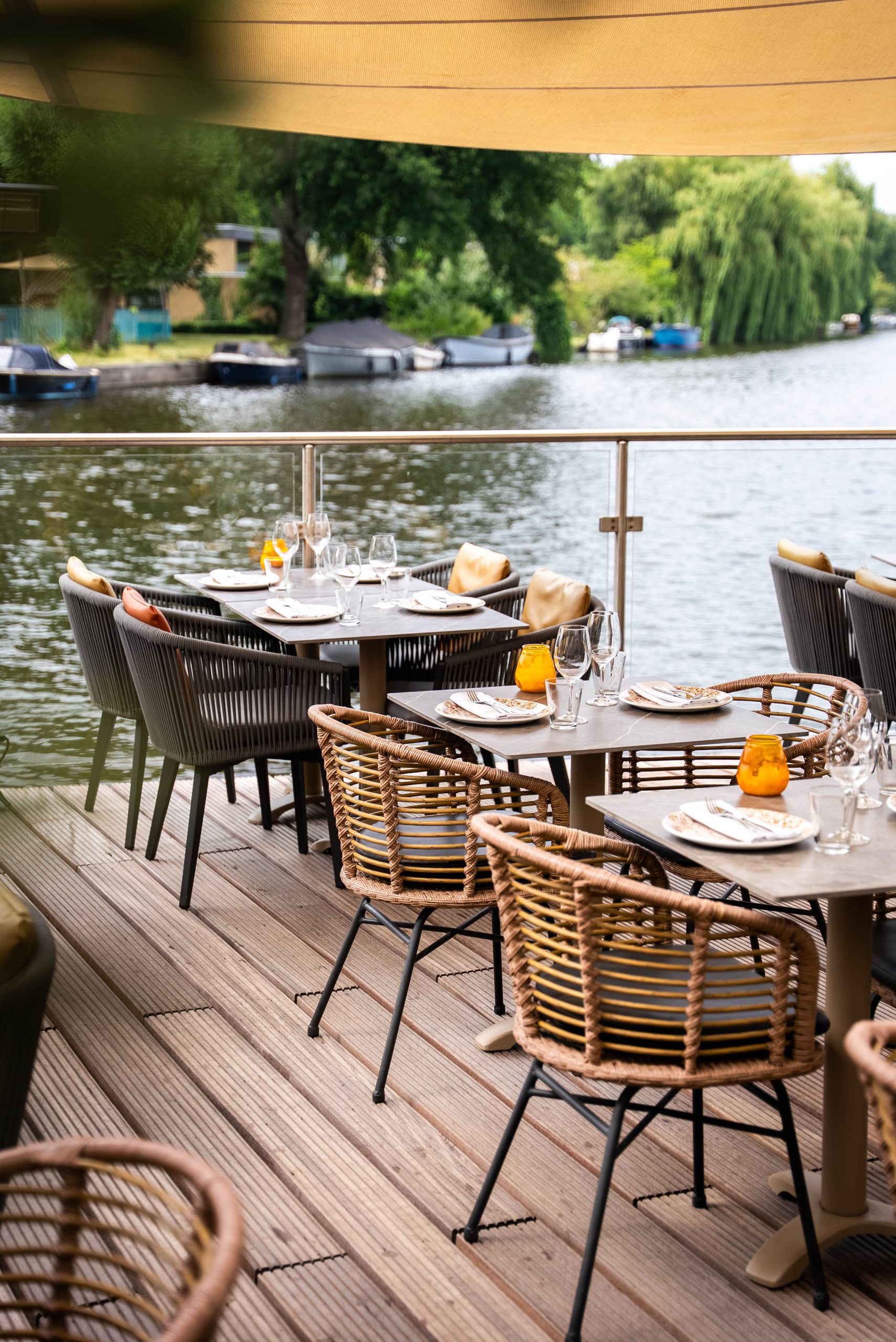 Terrastafels van Cedars aan het water met bootjes op de gracht