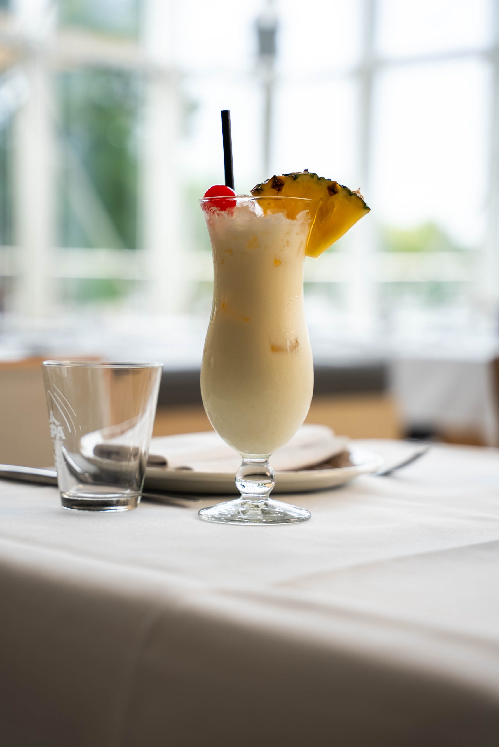 Romige cocktail met ananas op een wit gedekte tafel