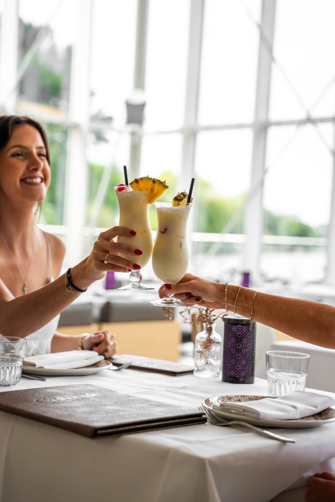 Twee gasten proosten met een cocktail van de bar van Cedars