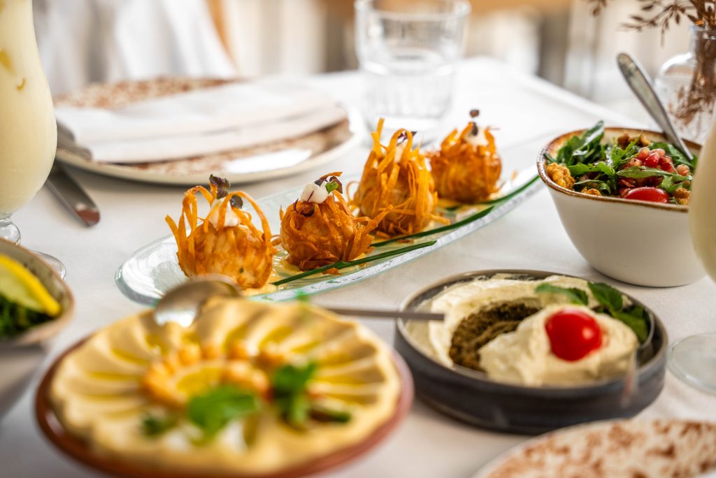 Rijkgevulde tafel met Libanese mezze en warme voorgerechten