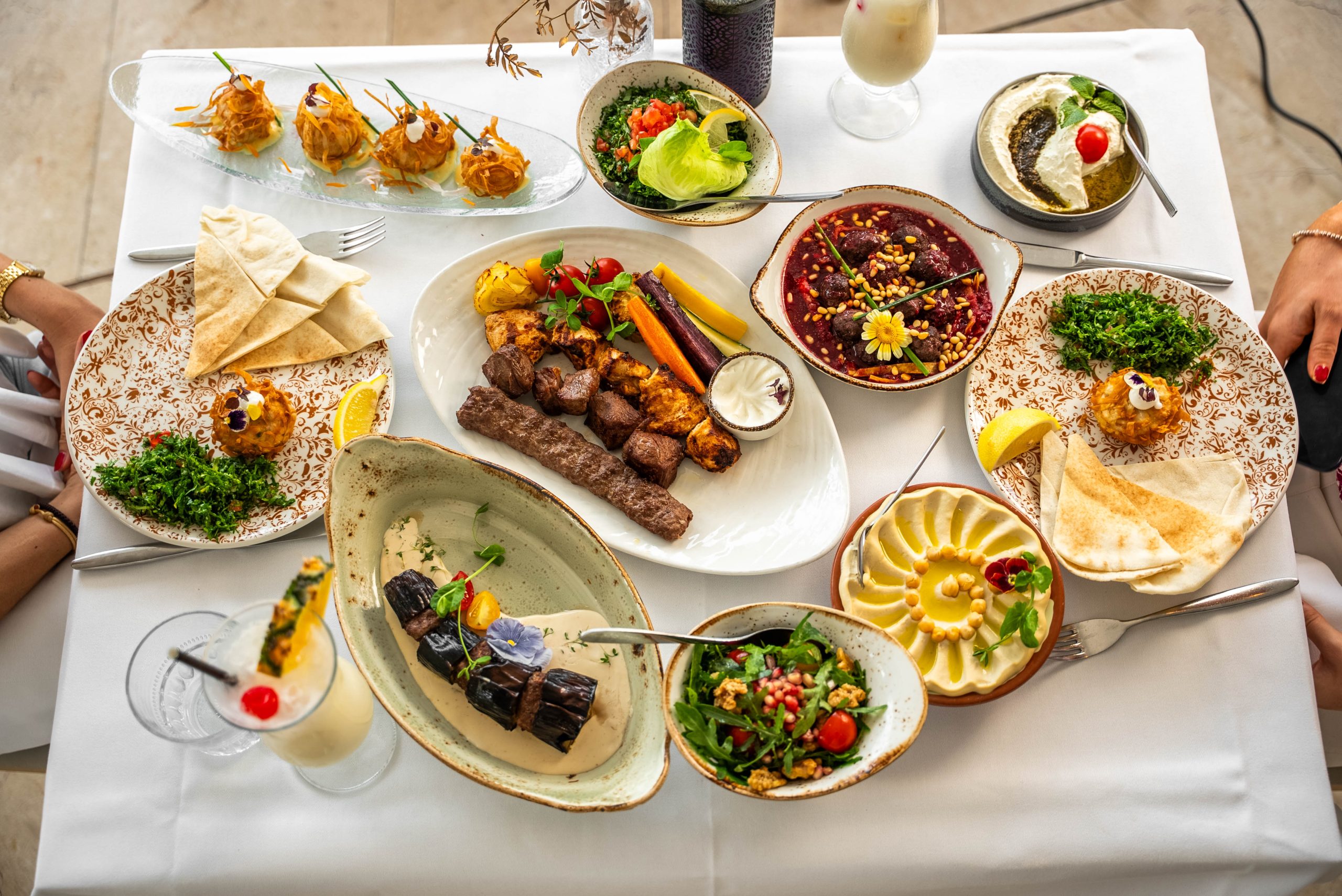 Bovenaanzicht van een rijkgevulde Libanese mezzetafel bij Cedars