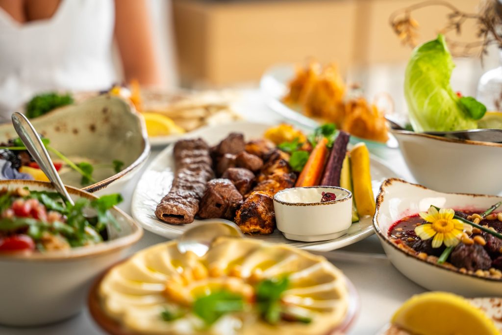 Tafel met gemengde grill, hummus en salades om te delen