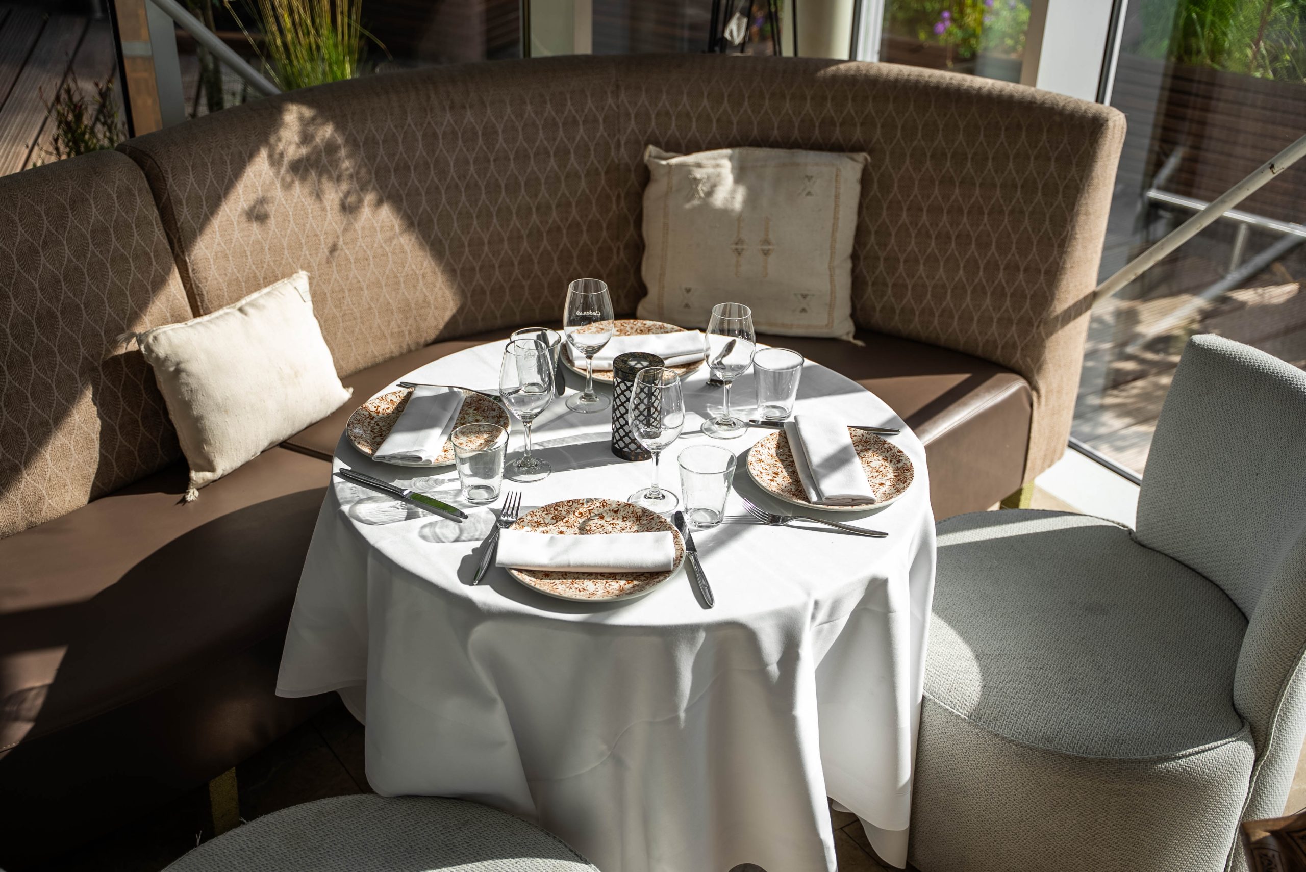 Rond gedekte tafel met loungebank voor een gezelschap bij Cedars