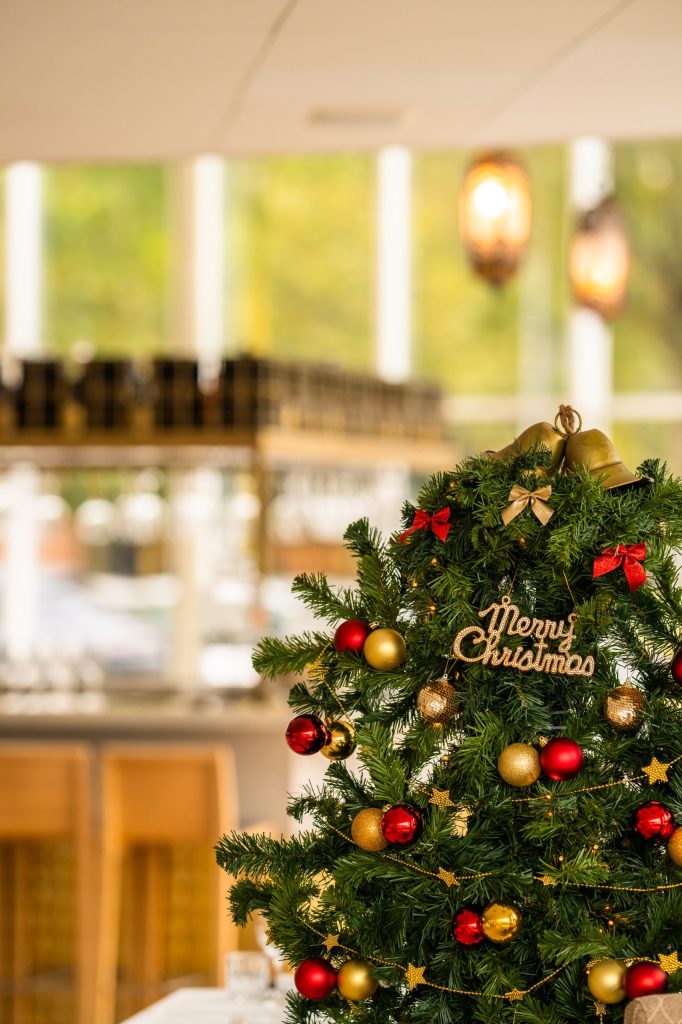 Versierde kerstboom met rode en gouden ballen in Restaurant Cedars